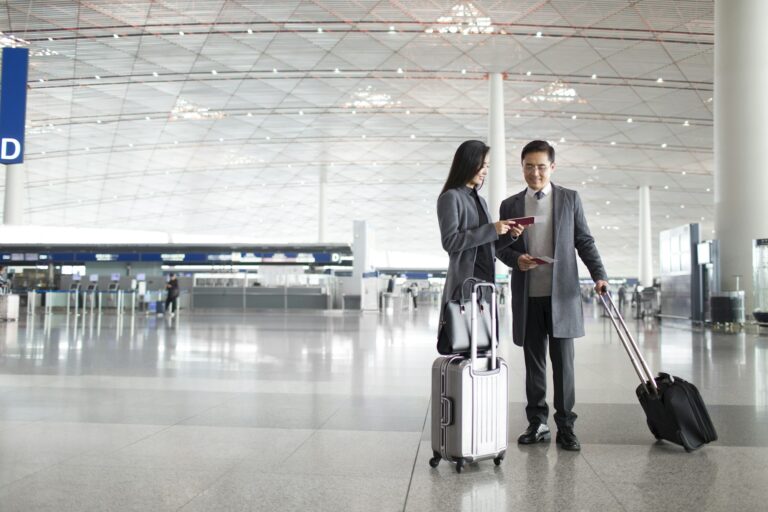 Business people with wheeled luggage in airport lobby