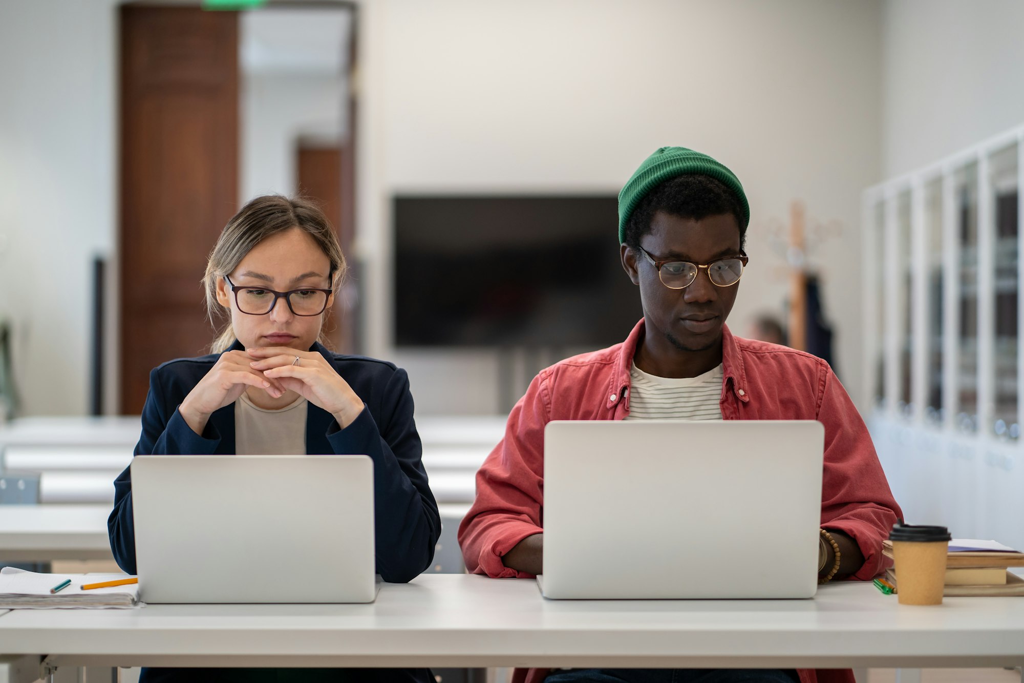 Diverse multiethnic focused students studying foreign language training center classroom with laptop